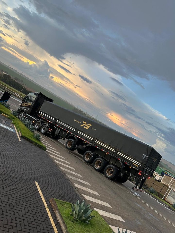 Rodotrem graneleiro Randon preto da Delamura ao entardecer